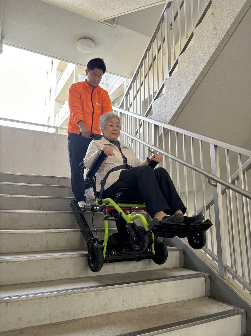 マンション階段での避難支援：スタッフが高齢居住者を階段昇降機で搬送